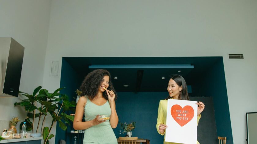 Two women enjoying healthy food and promoting nutrition awareness in a modern kitchen.