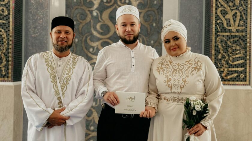 A couple celebrates their Islamic wedding with an imam indoors.