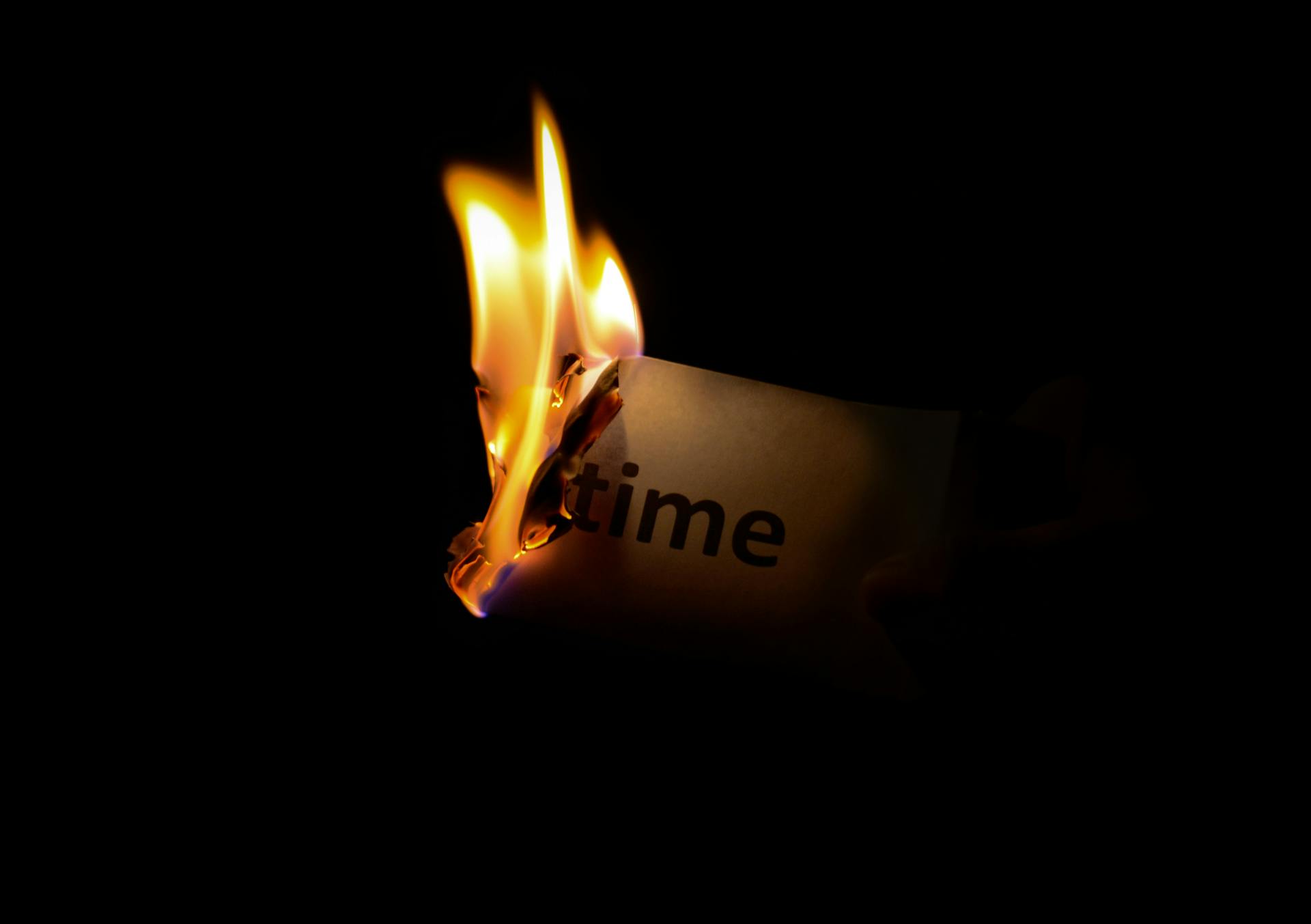 Burning paper with the word 'time'