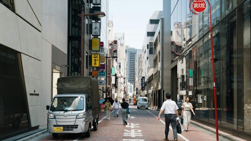 Street view of Chūō, Tokyo with people and vehicles on a sunny day.