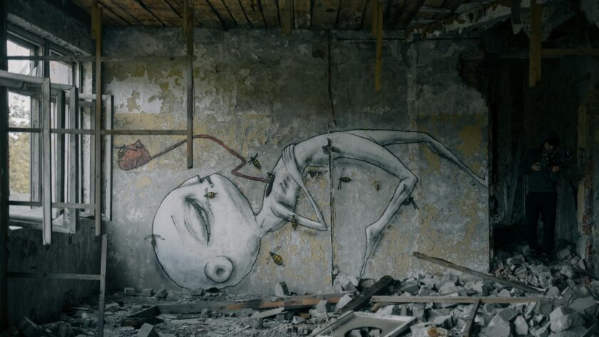 A decaying room featuring surreal graffiti art amidst rubble, capturing urban desolation and decay.