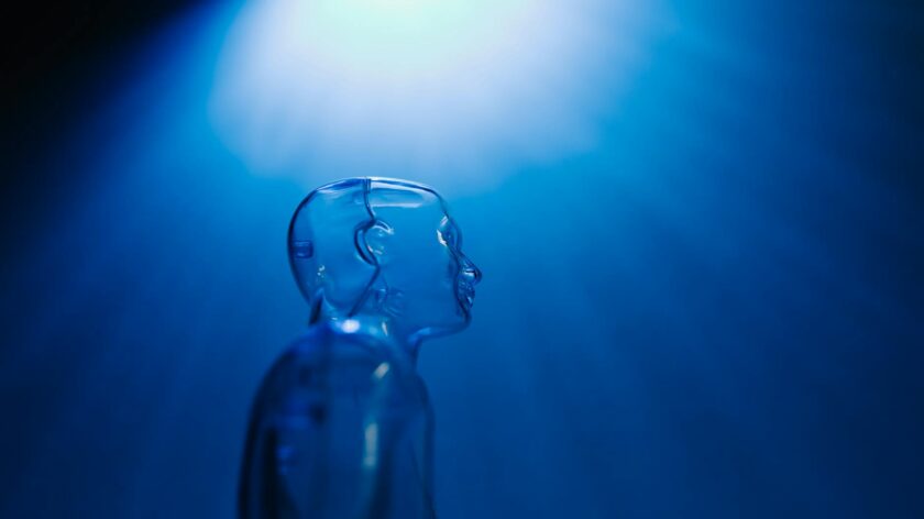Transparent robotic figure illuminated by blue light, symbolizing AI and futuristic technology.