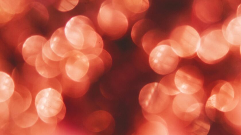 Abstract red bokeh lights create a warm, sparkling background perfect for festive designs.
